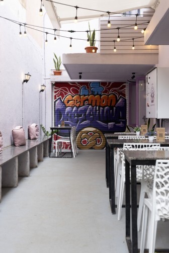 Outdoor seating area with German-themed mural and string lights